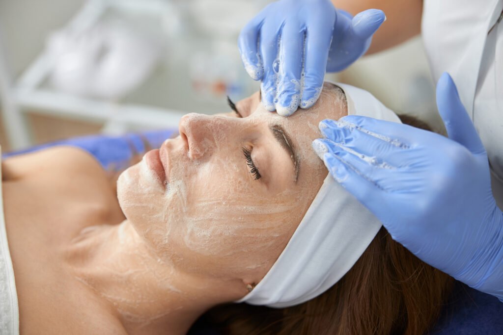 Professional cosmetologist is doing procedures for client in light cabinet
